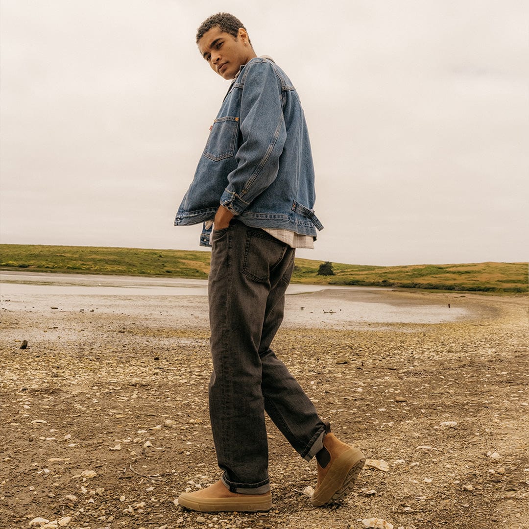 Model seated wearing SeaVees Ballard Boot in Cashew, highlighting its versatile look.