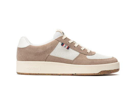 Side view of the Cardinal Sneaker in Latte showcasing the blue, red, and white tag and mesh detailing on the side of the shoe and thick white sole