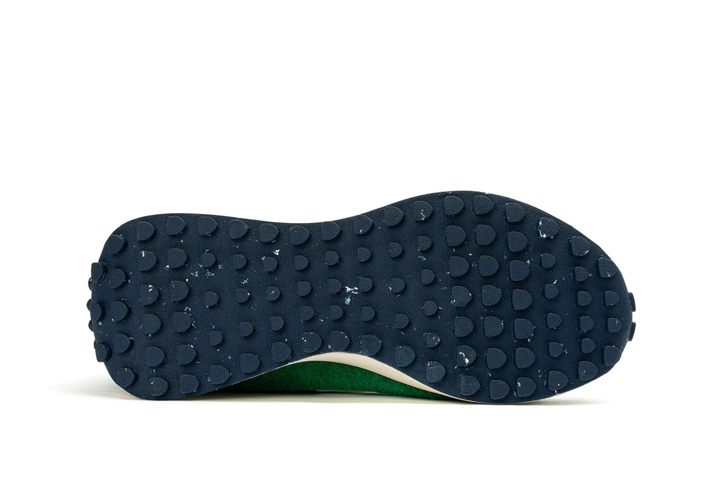 The sole of a SeaVees 'Acorn' sneaker in Grass Green, highlighting the navy outsole with its tread pattern.