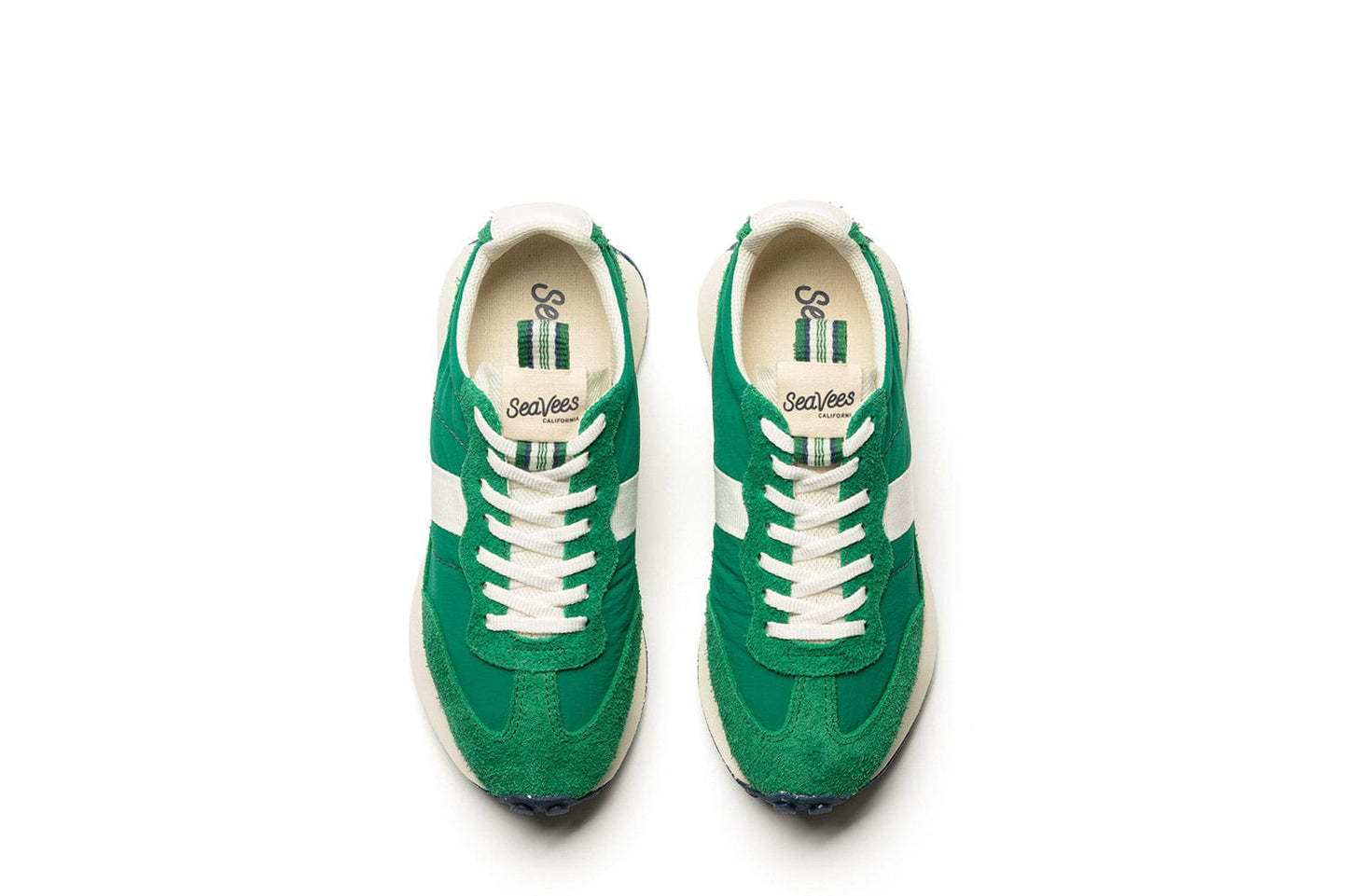 Top-down view of the Acorn Trainer in the color Grass Green, showcasing the white laces, branding, and pull tab.