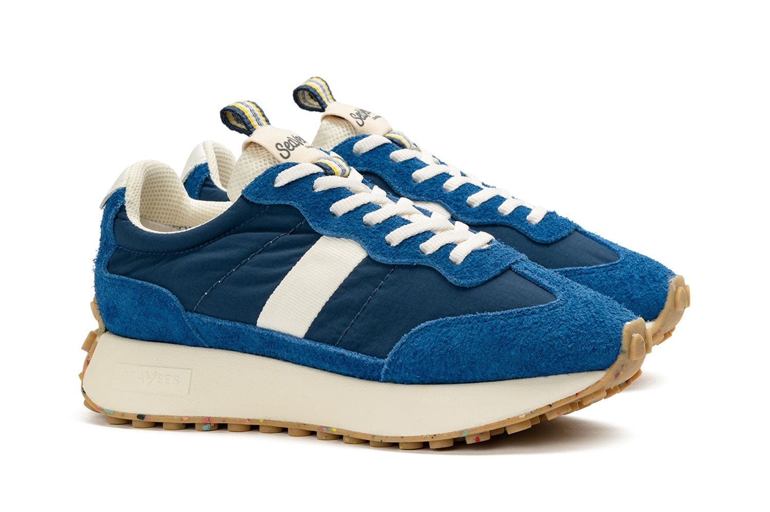 Angled side view of the Acorn Trainer in the color Varsity Blue, showcasing the white laces, thick sole, and side detailing.