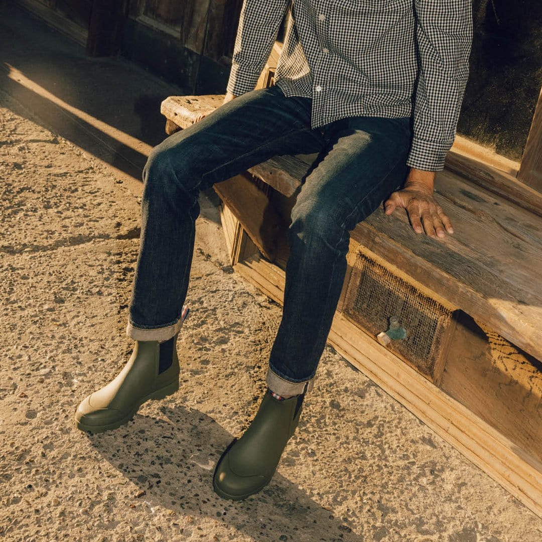 Man seated outdoors wearing Bolinas Off Shore Boots in Military Olive, casual style.