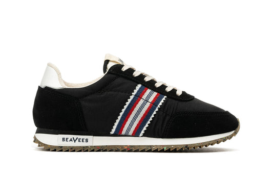 Side view of Royal Runner sneaker in Black featuring SeaVees logo and recycled bottom.