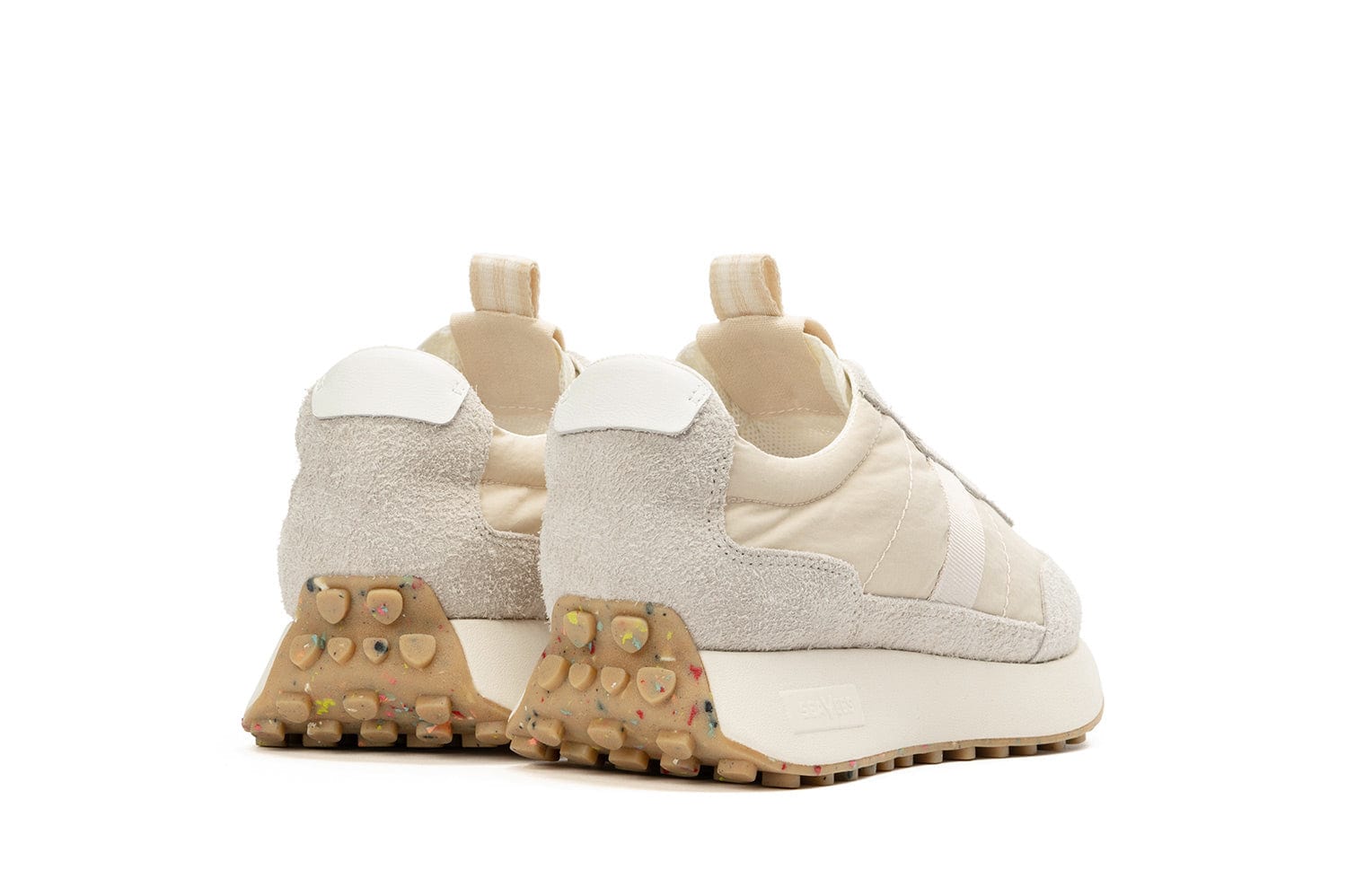 Rear-angled view of the Acorn Trainer in the color Cloud, showcasing a pull tab and the recycled material sole.