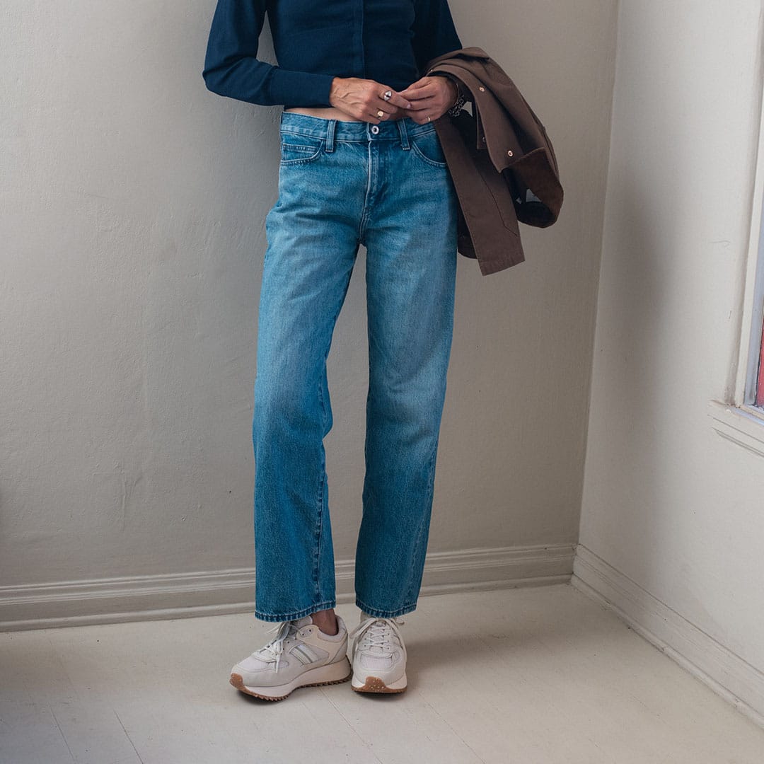 Women's Causeway Trainer sneaker in Cloud mesh and leather, worn by a person standing in straight jeans in a white room