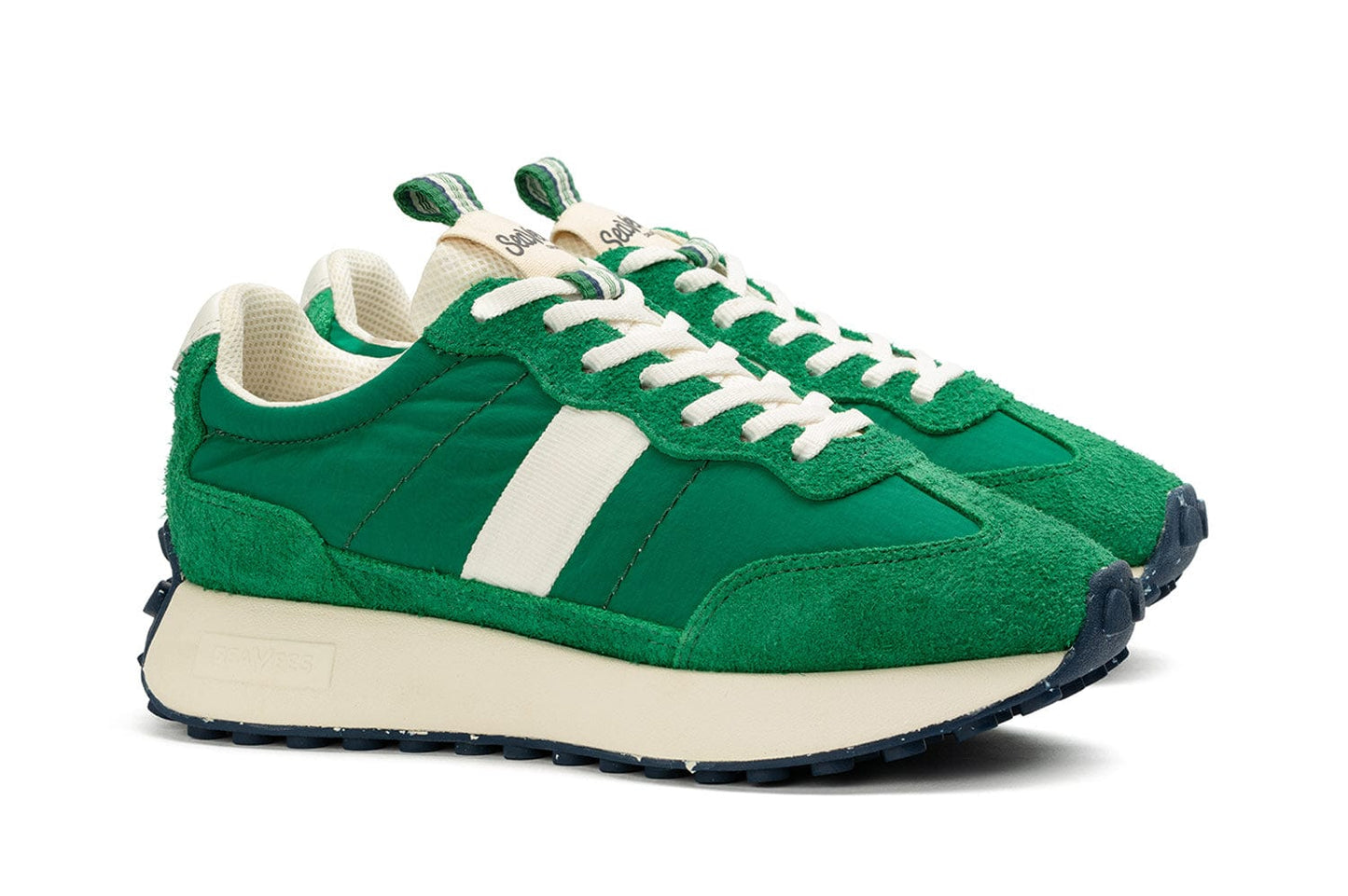 Angled front view of the Acorn Trainer in the color Grass Green, showcasing the side detailing, pull tab, and white laces.