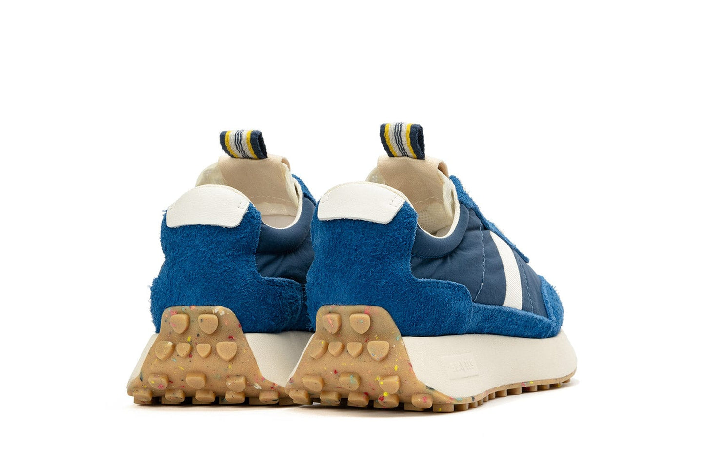 Rear angled view of the Acorn Trainer in the color Varsity Blue, showcasing the blue, white, and yellow pull tab and recycled sole.