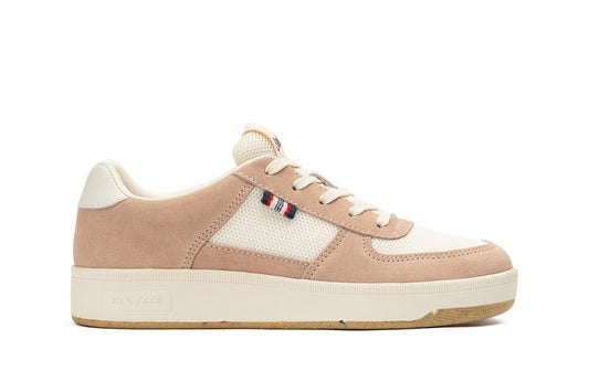 Side view of the Cardinal Sneaker in Pink Sand, showcasing the blue, red, and white tag on the side of the shoe and thick white sole