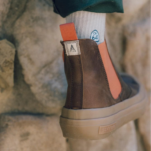 Detailed view of Beyond & Back Boot's heel in Elmwood, showing off the pull tab and elastic side panel with a leafy background