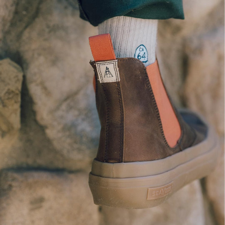 Detailed view of Beyond & Back Boot's heel in Elmwood, showing off the pull tab and elastic side panel with a leafy background